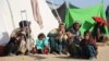 Families who fled their villages after the Taliban launched massive attacks in different districts of Helmand Province live in temporary shelters in the provincial capital of Lashkar Gah on November 24.