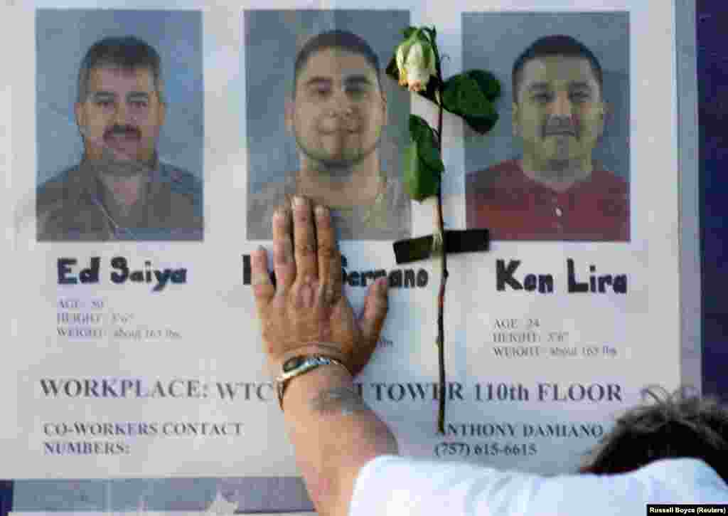 16 сентября мужчина, приложив руку к стене с фотографиями пропавших людей у больницы Белвью в Нью-Йорке, еще надеется, что они живы. Сотрудники служб быстрого реагирования и реанимационных бригад, многие из которых сами потеряли коллег, членов семьи и друзей, в течение месяцев продолжали усилия по поискам останков и расчистке завалов