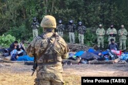 მიგრანტების ჯგუფის ფოტო შეიარაღებულ პოლონელ სამხედრო მოსამსახურესა (წინა პლანზე) და ბელარუსის პოლიციას შორის. დაპირისპირება ხდება ძირითადად ახლო აღმოსავლეთიდან მომავალი მიგრანტების ტალღის ფონზე, რომლებიც არალეგალურად შემოდიან ევროპის კავშირში ბელარუსიდან. ევროკავშირის ხელისუფლება მინსკს ადანაშაულებს კრიზისის განზრახ შექმნაში, რასაც ის აკეთებს სანქციების საპასუხოდ, რომელიც ევროპის კავშირმა დაუწესა მას შემდეგ, რაც ბელარუსის ლიდერმა ალიაქსანდრ ლუკაშენკამ რეპრესიები დაიწყო შარშანდელი სადავო არჩევნების შემდეგ.