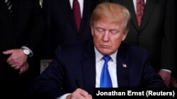 Američki predsjednik Donald Trump potpisuje memorandum o tarifama za visoko tehnološke proizvode iz Kine, 22. mart 2018.