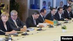 Бэльгія - Сустрэча лідэраў Эўразьвязу 7 ліпеня 2015 году, (зьлева направа) канцлер Нямеччыны Ангела Мэркель, прэзыдэнт Эўрапейскай камісіі Жан-Клод Юнкер, прэзыдэнт Эўрапейскага цэнтральнага банку Марыё Драгі, прэзыдэнт Францыі Франсуа Алянд, прэм'ер-міністар Гішпаніі Марыяна Рахой, прэм'ер-мінісар Грэцыі Алексіс Цыпрас