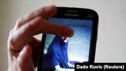 Alema Dolamić pokazuje fotografiju sestre Adele koja je, s troje djece, više od dvije godine u kampu Roj na sjeveru Sirije. 