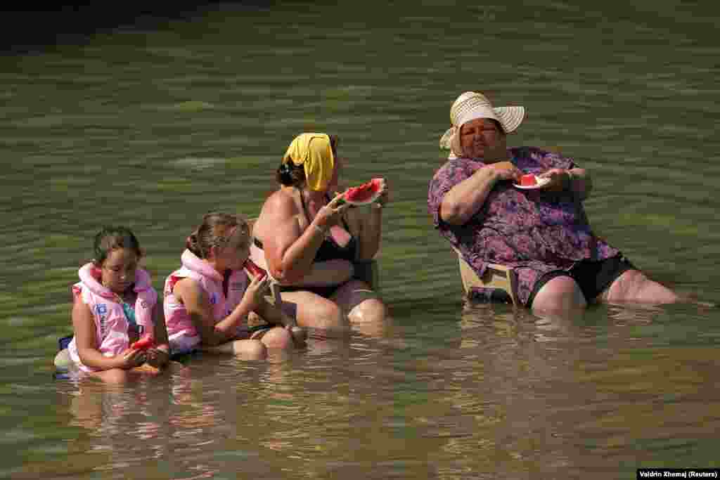 Përveç freskisë nga uji i Erenikut, këto gra dhe fëmijë janë freskuar edhe me shalqi. 
