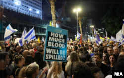 Една от присъстващите на протеста в Тел Авив държи плакат с надпис "Колко кръв ще бъде разлята?"