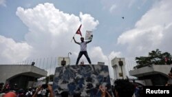 Učesnik protesta maše zastavom Nepala na ulazu u parlament, Katmandu, 8. septembar 2025.