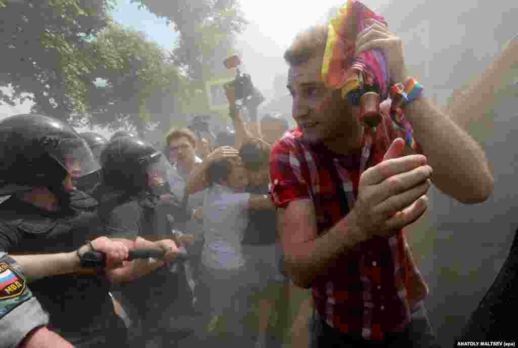 Rights activists run a gauntlet of riot police as debris rains down during a gay pride event in St. Petersburg in 2013. 