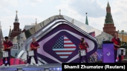 Učesnici nastupaju pored ekrana na kojem je prikazana zastava Sjedinjenih Država tokom ceremonije kojom je obeleženo 100 dana odbrojavanja do početka takmičenja za pesmu Intervizije, blizu Kremlja u centru Moskve, Rusija, 12. juna 2025.