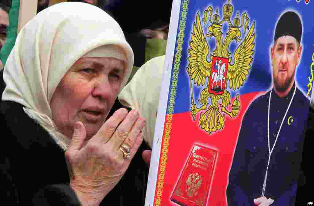 Чеченська жінка тримає фото Кадирова
