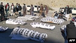 Members of Pakistan's Shi'ite Hazara community attend to the bodies of 11 miners who were killed by gunmen in Balochistan Province.