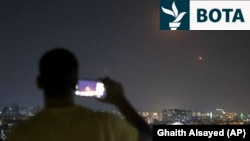 Një person në Damask të Sirisë incizon me telefonin e tij raketat e lëshuara nga Irani drejt Izraelit. 18 qershor 2025. 