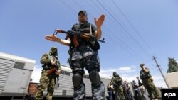 Сепаратисты в оцеплении вагона-рефрижератора с останками тел погибших в авиакатастрофе 