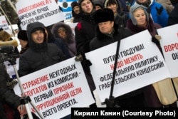 Протестующие с плакатами на митинге против концессий в Новосибирске