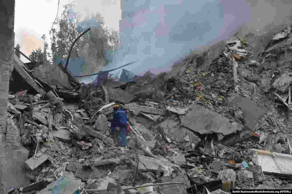 Spasilac pretražuje tinjajuće ruševine zgrade u Kijevu. Nekoliko stanovnika zgrade se vodi kao nestalo.