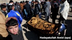 People attend the funeral ceremony of a victim who was killed in twin bombings that targeted the parliament building in Kabul last month.