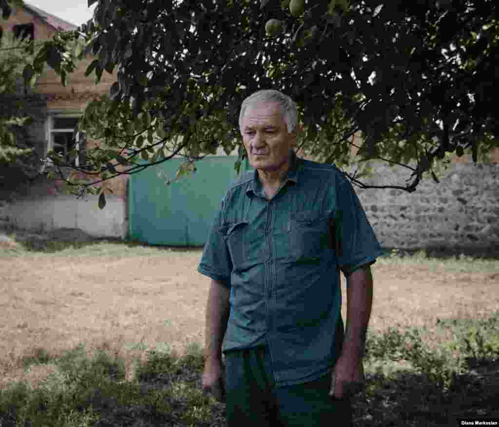 "I feel like she is still with us," says Ruslan Kokov, 63. Ruslan was at the market when Oksana walked across the road to school, never to return. On her birthday, Ruslan and his son, Uruzmag, 27, always lay a place for her at dinner. They eat the foods she liked: melon, persimmons, blood oranges. Ruslan is pictured here standing in front of his house on Komintern Street. School No. 1 is clearly visible from his front room. Russian special forces were staked out there during the siege; during the final gun battle, bullets shattered his two front window panes. Ten years later, Ruslan hasn't gotten around to fixing them. "When I come across something that reminds me of the tragedy, it just upsets me unnecessarily," he says.