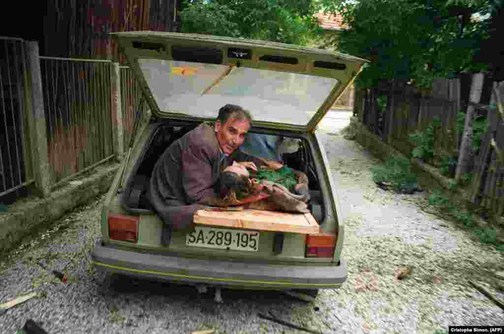 Čovjek drži glavu žene ranjene u granatiranju, 27. juni 1992. 