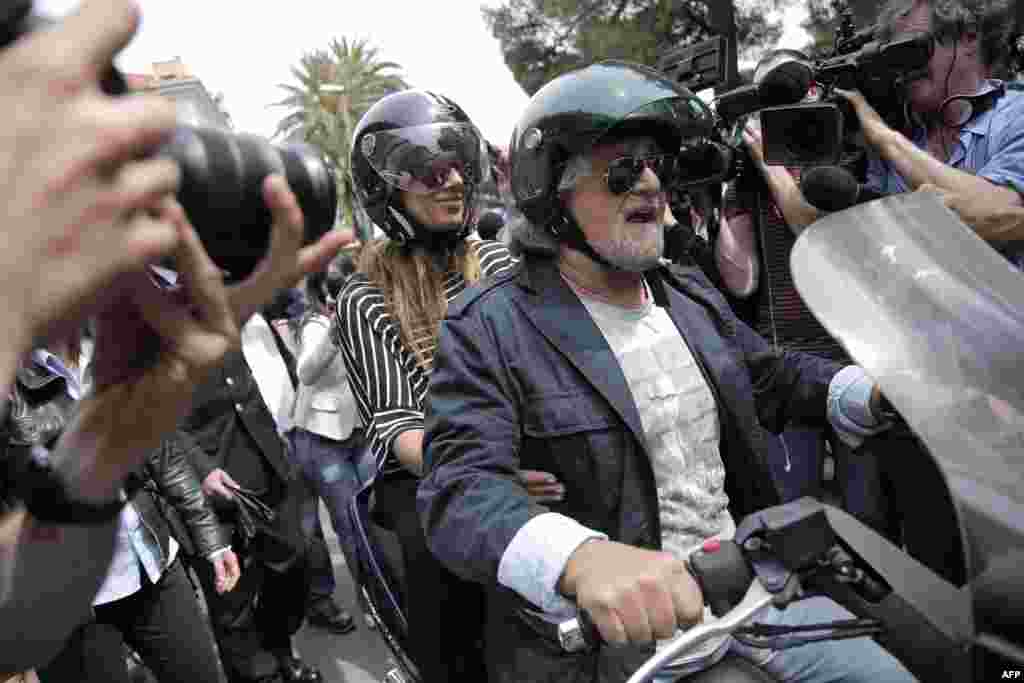 На мотоцикле - бывший актер-комик, ныне лидер итальянского популистского "Движения 5 звезд" Беппе Грилло. Его движение заняло на выборах в Европарламент второе место. Грилло и его сторонники настаивают на проведении референдума о выходе Италии из еврозоны.  