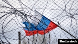 Ruska zastava se vijori iza ograde i bodljikave žice (ilustrativna fotografija)