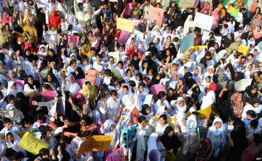 Students of Farooqi Girls' High School wave placards as they stage a protest in Lahore on November 3, demanding the reopening of their school after it was set on fire by an angry mob that alleged the school gave a test that insulted the Prophet Muhammad.