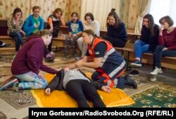 Инструктор проводит занятия для детей из интерната по оказанию медицинской помощи