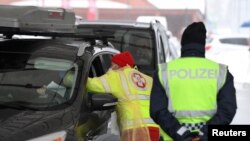 A medic checks the temperature of a driver coming from Italy due to the spread of the coronavirus disease