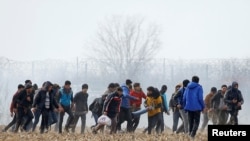 Migranti nose povrijeđenog čovjeka pored turskog graničnog prelaza Pazarkula sa Grčkom, 4. mart, 2020. 
