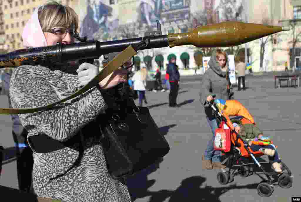 Жінка з гранатометом під час відкриття акції «Захисти свою країну» на площі Свободи у Харкові, 19 жовтня 2014 року. Акція спрямована на навчання населення методам поводження з різними видами зброї та бойової техніки в рамках посилення обороноздатності міста та області.