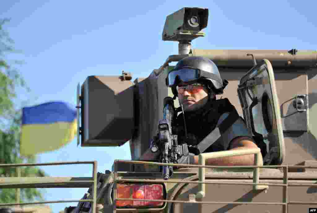 Місто Ізюм – вояк на БТРі нового покоління, які нещодавно отримала українська армія. Україна планує залучити близько 55 тисяч міліціонерів і 20 тисяч волонтерів для того, щоб гарантувати безпеку під час президентських виборів 25 травня