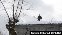 დიდთოვლობა გურიაში - ოზურგეთში კაცი სახლის სახურავს თოვლისგან ასუფთავებს