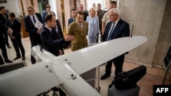 Ministrul de externe al Ucrainei, Andrii Sibiha (dreapta) și omologul său polonez Radoslaw Sikorski la o expoziție ucraineană de drone în KIev, pe 12 septembrie