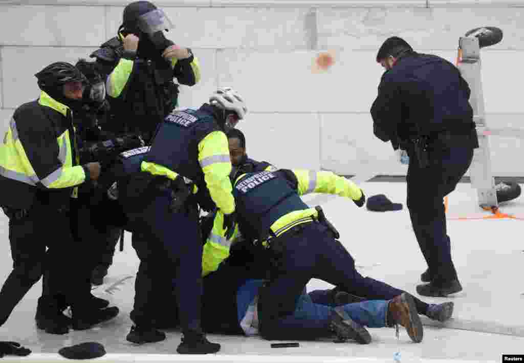 Policijski službenici priveli su pristalicu predsjednika SAD Donalda Trampa, tokom sukoba na skupu koji je osporavao potvrđivanje rezultata američkih predsjedničkih izbora 2020. od strane Kongresa SAD-a, ispred zgrade američkog Kapitola u Washingtonu, SAD, 6. januara 2021. godine.