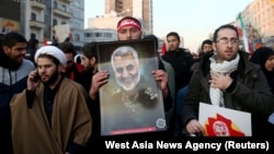 Похоронная процессия в Тегеране. Люди несут портреты Касема Сулеймани