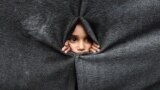 Raseljeno palestinsko dijete gleda kroz zaklon napravljen od ćebadi u školi koju vodi UNRWA nakon što je američki predsjednik Donald Trump objavio da su se Izrael i Hamas složili oko prve faze primirja u Gazi, Han Junis na jugu Pojasa Gaze, 9. oktobar 2025. 