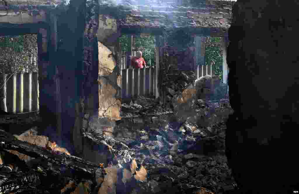 Місцевий житель біля руїн будинку, який був знищений в результаті бою між між озброєними сепаратистами і українською армією в селі Семенівка біля Слов’янська, 23 травня 2014 року