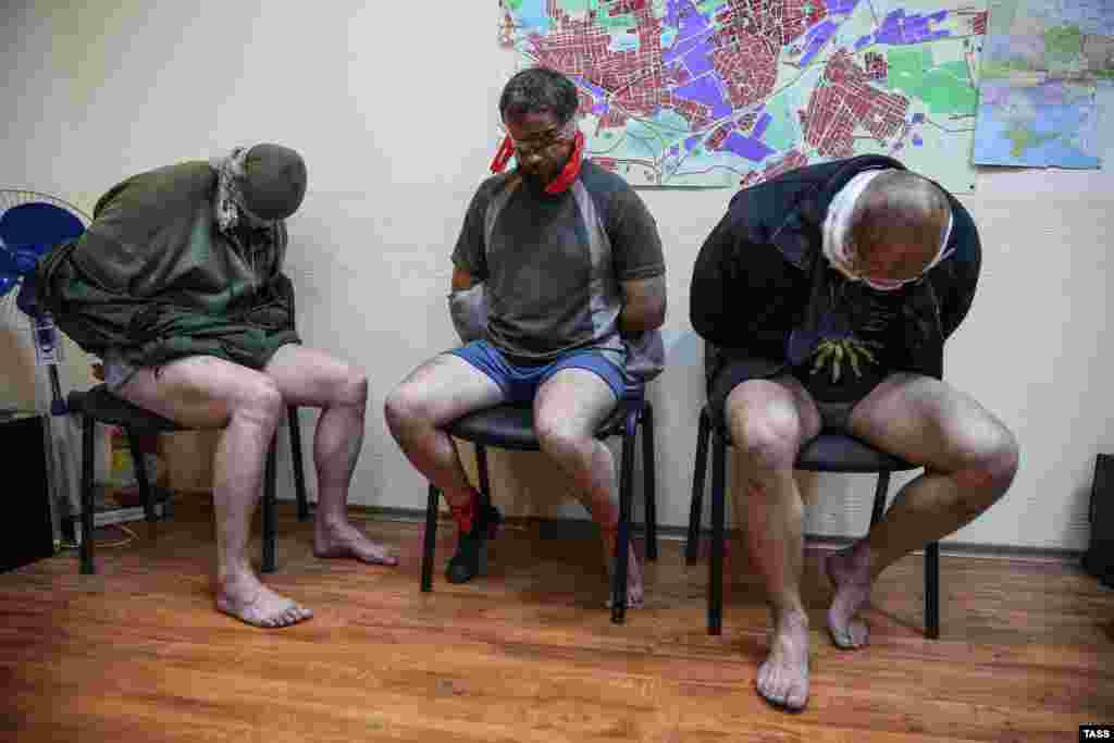 Проросійські бойовики демонструють пресі трьох співробітників СБУ, захоплених у Горлівці, 27 квітня 2014 року