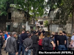 ჩამონგრეული სახლის ბინადრები შენობის უკან არიან შეკრებილები