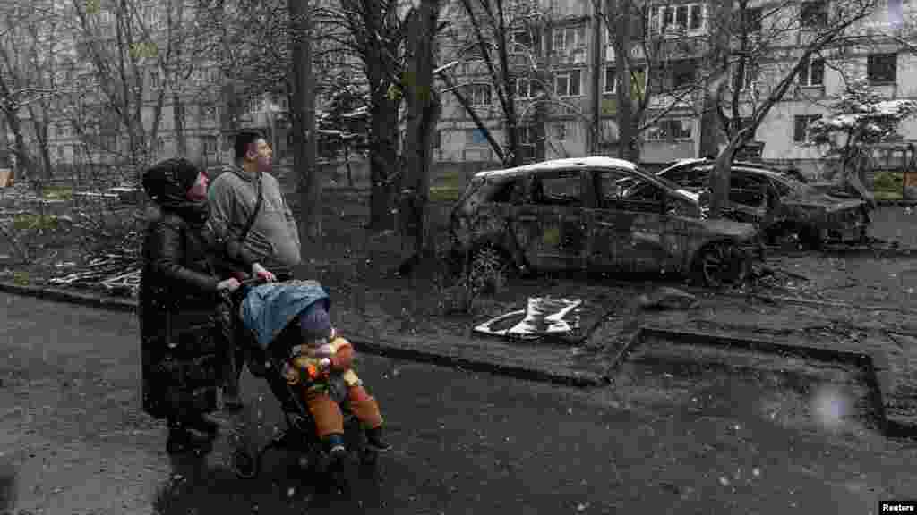 Mještani prolaze pored spaljenih automobila na mjestu ruskog napada dronom u Dnjepru, Ukrajina, 9. aprila.