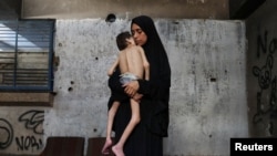 Raseljena Palestinka Samah Matar drži u naručju svog pothranjenog sina Youssefa, koji boluje od cerebralne paralize, u gradu Gazi, 24. jula 2025.