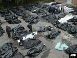 Na slici rođaci pokušavaju da identifikuju tela žrtava ispred mrtvačnice u Vladikavkazu Prvog septembra 2004. godine čečenski militanti su upali u osnovnu školu u Beslanu u ruskoj republici Severna Osetija. Za taoce uzeli su 1100 učitelja, dece i njihovih rođaka. Dva dana kasnije, ruske bezbednosne snage su uletele u zgradu. Posledično 330 talaca je umro, od toga 186 dece.