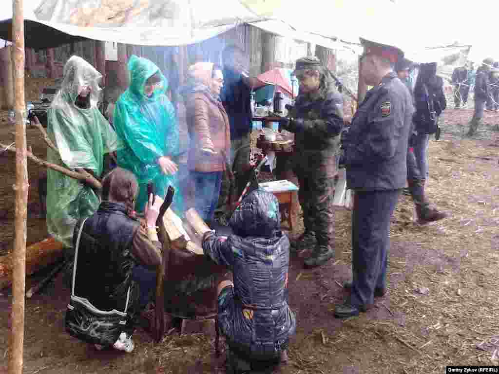 Полицейский греется у костра в эколагере