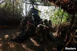 Вояки 148-ї окремої артилерійської бригади цілять з гаубиці М777 по російській техніці. Донеччина, 1 травня 2024 року