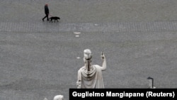 Čovjek šeta psa na pustom trgu Pijaca del Popolo (Piazza del Popolo), u Rimu, 13. marta 2020.
