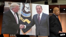 Elajdža Kamings prolazi pored fotografije Donalda Trampa i ruskog šefa diplomatije Sergeja Lavrova