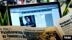 Putnik na moskovskom aerodromu čita vesti o Snoudenu, jun 2014.