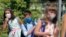 Alegra Bajrami (left), wearing a face mask to protect against the coronavirus, enters a schoolyard on the first day of the new academic year in Kosovo&#39;s capital, Pristina. Kosovar schools reopened on September 14 for the first time since March when the COVID-19 crisis began.
