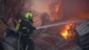 Рятувальник гасить пожежу, що виникла внаслідок російської атаки, Київ, 6 квітня 2025 року