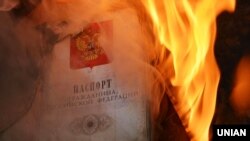 Палаючий паспорт громадянина Росії біля будівлі російського генерального консульства в Одесі під час акції вшанування пам’яті жителів Маріуполя, вбитих в результаті обстрілу російських гібридних сил. Одеса, 25 січня 2015 року