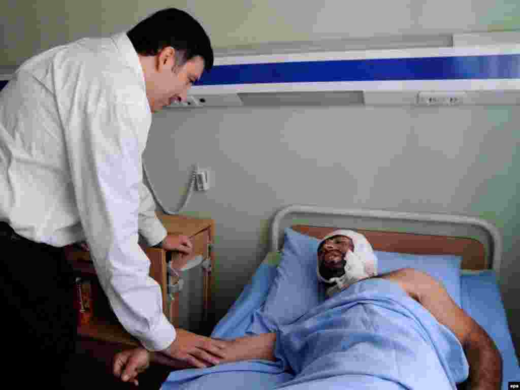 Раиси ҷумҳури Гурҷистон, Михеил Саакашвилӣ дар аёдати захмии бобмаборонҳои Русия. - Caption: epa01436724 Georgia's President Mikhail Saakashvili speaks to a patient during a visit to a military hospital in Gori, about 80 km from Tbilisi, Georgia 07 August 2008. President Mikheil Saakashvili has ordered Georgian troops out of the South Ossetian capital