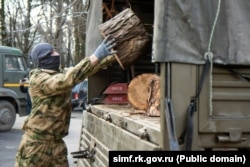 Российские военные в Симферополе загружают в грузовик спиленные деревья в рамках акции «Блиндажи в тепле», февраль 2025 года