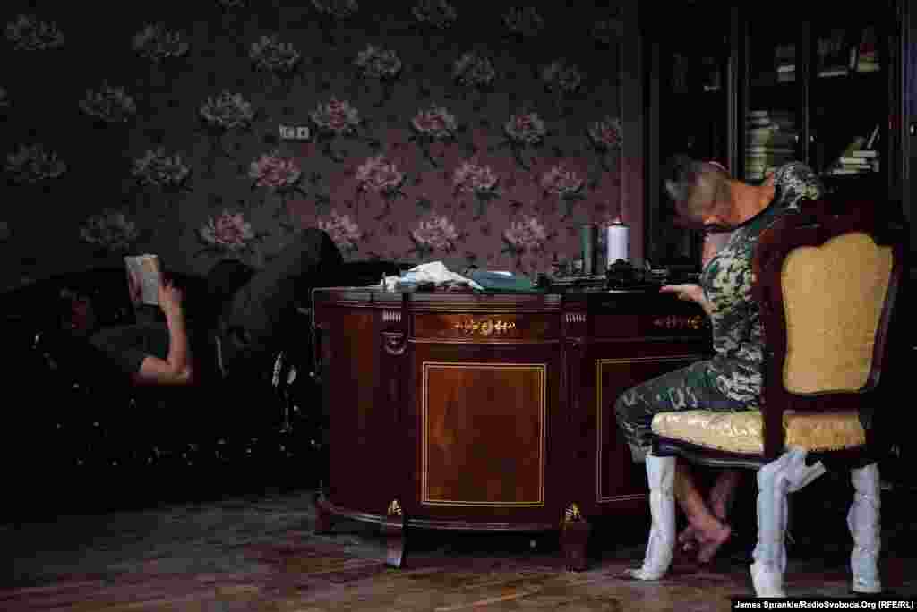 У перерві між обстрілами бійці йдуть у кімнату, де була розкішна бібліотека та офіс, аби почистити зброю та почитати  